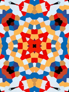 A vibrant, symmetrical kaleidoscope pattern featuring bold geometric shapes in various colors. The design is complex, with intersecting lines and layered segments creating a visually appealing mosaic-like effect.