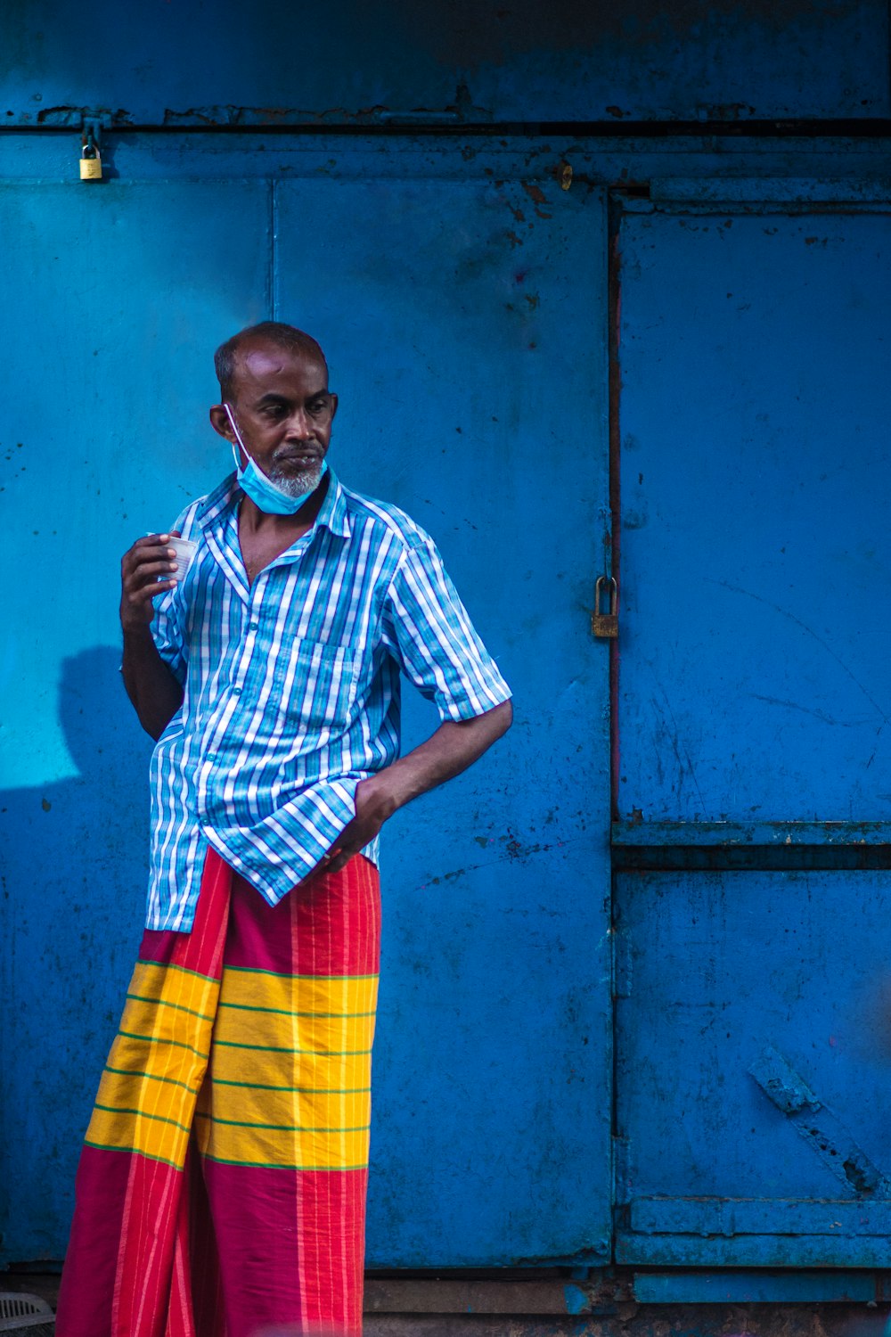 a man standing in front of a blue wall