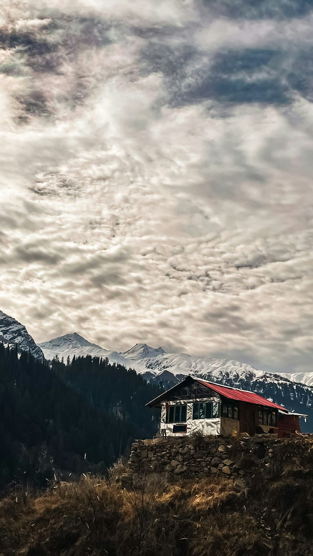 a house on a hill with mountains in the background