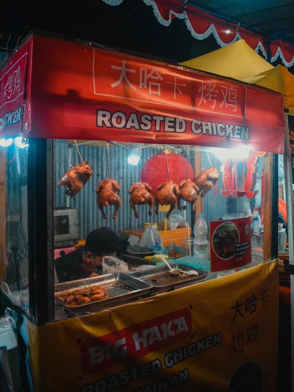 a food stand with chicken hanging from it's sides