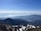 A panoramic view of Swiss cable cars ascending over alpine terrain with distant mountains.