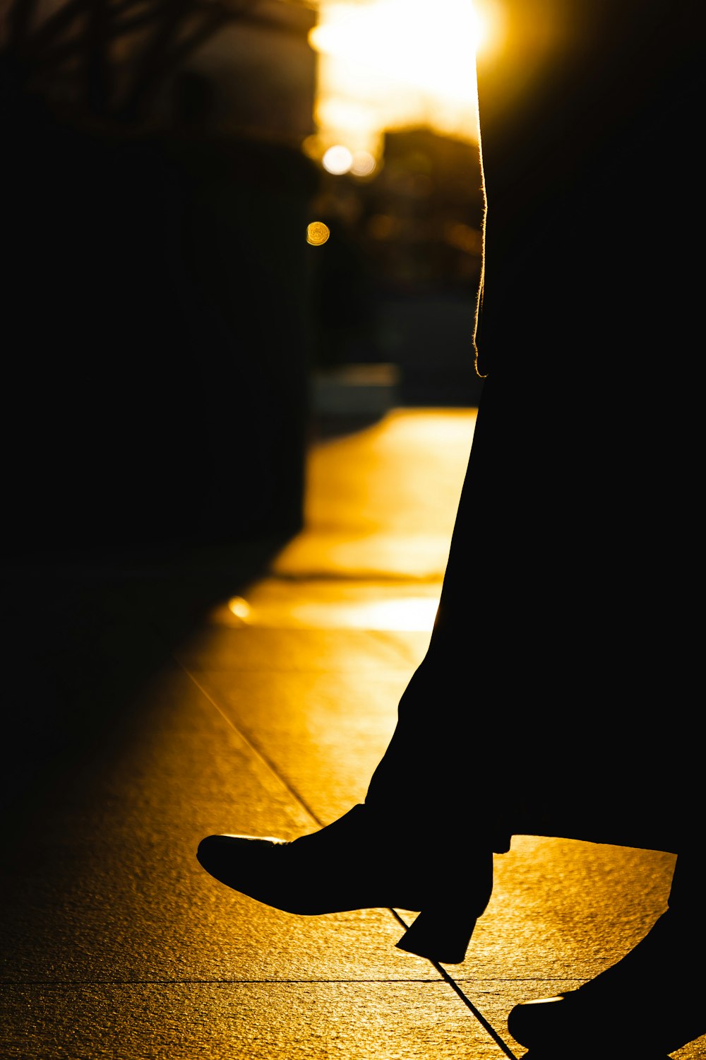 a person standing on a sidewalk with their feet up