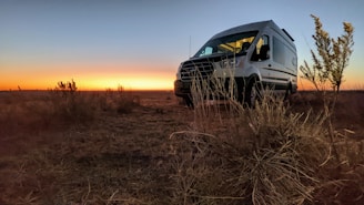 Mobile tire service van parked on a roadside at sunset.