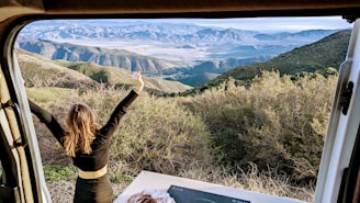 Elegant traveler admiring a stunning mountain vista during a luxury tour
