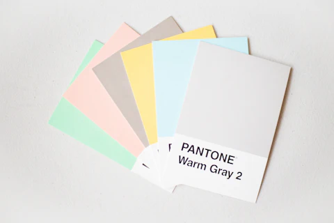 A grid of Pantone color swatches in warm gray and neutral tones laid out against a white background