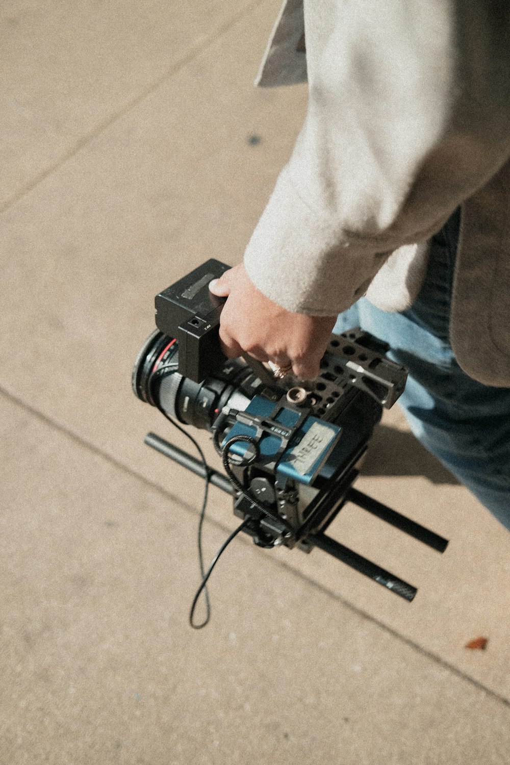 a man is holding a camera on a tripod