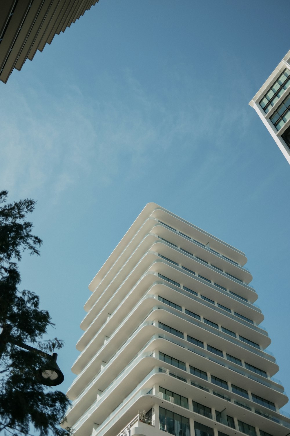 a tall white building sitting next to a tall building