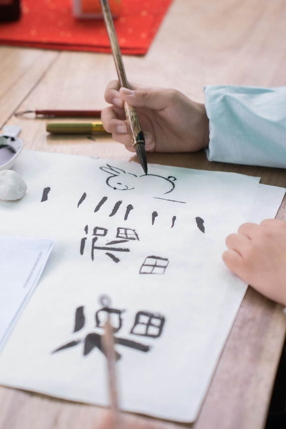 a person writing on a piece of paper with a pen