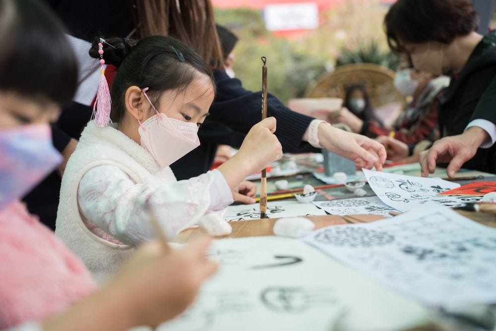 a group of people sitting around a table with drawings on it