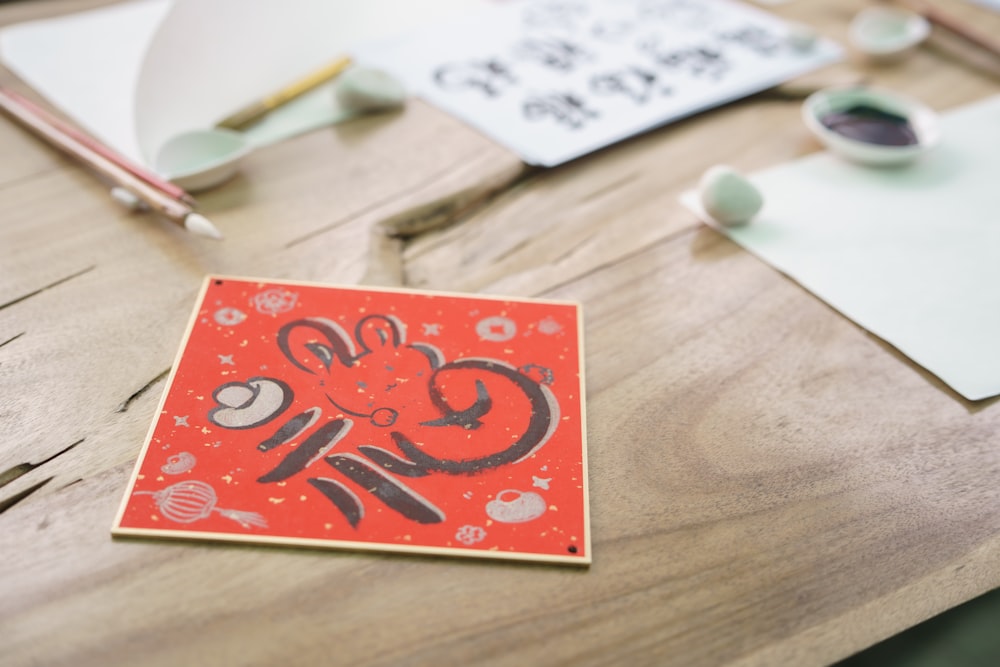 a wooden table topped with a red card