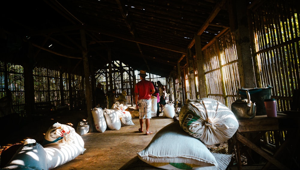 a man standing in a room with lots of bags