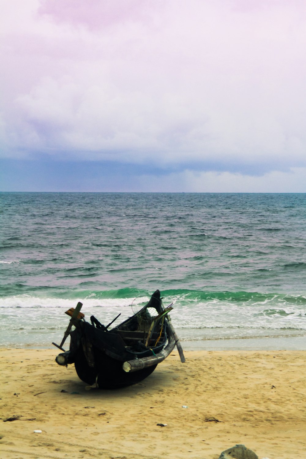 a boat sitting on top of a sandy beach