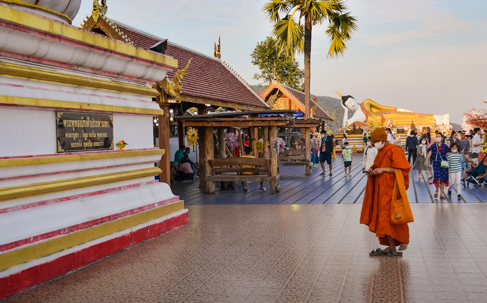 Ein Mönch in orangefarbenen Gewändern geht eine Straße entlang