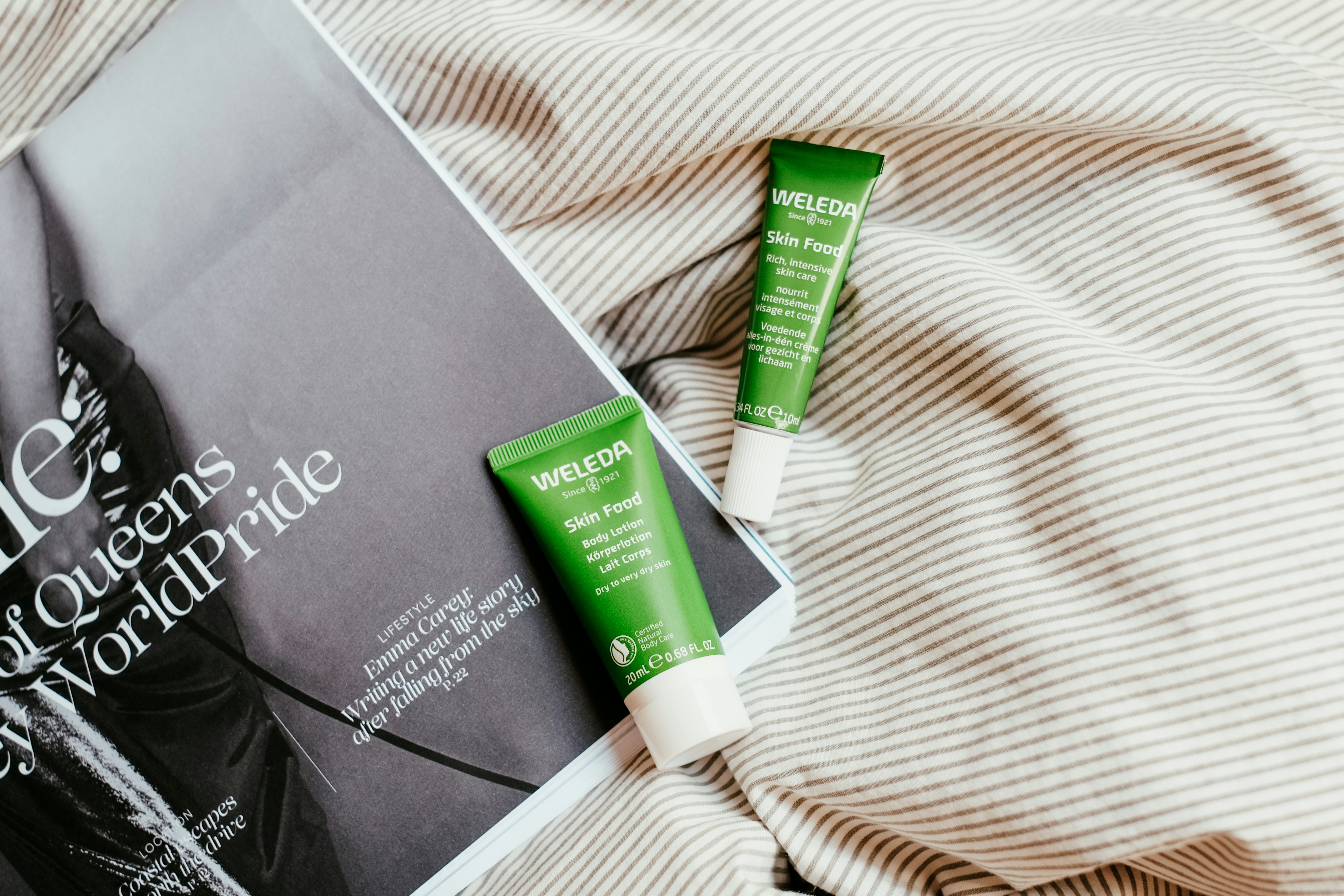 A couple of tubes of toothpaste sitting on top of a bed photo Free