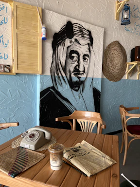 Cozy coffee shop counter with a vintage telephone and a small potted plant.