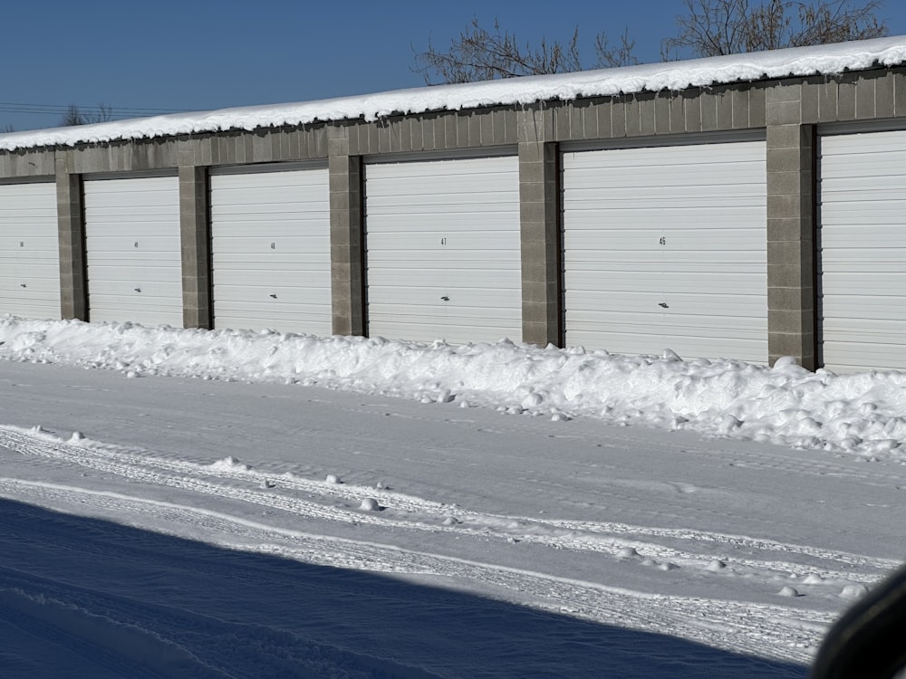 a row of garages with snow on the ground