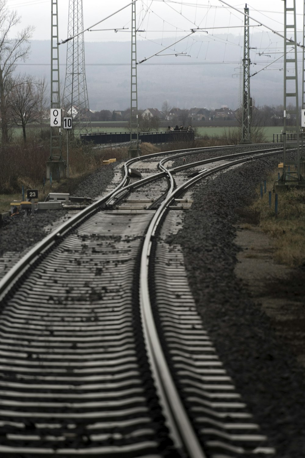 a set of train tracks with power lines in the background