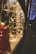 Warm white string lights are wrapped around and hang in front of a window, creating a festive atmosphere. A red gift with a checkered pattern is partially visible, suggesting a holiday or celebratory setting. The lights cast a cozy and inviting glow.