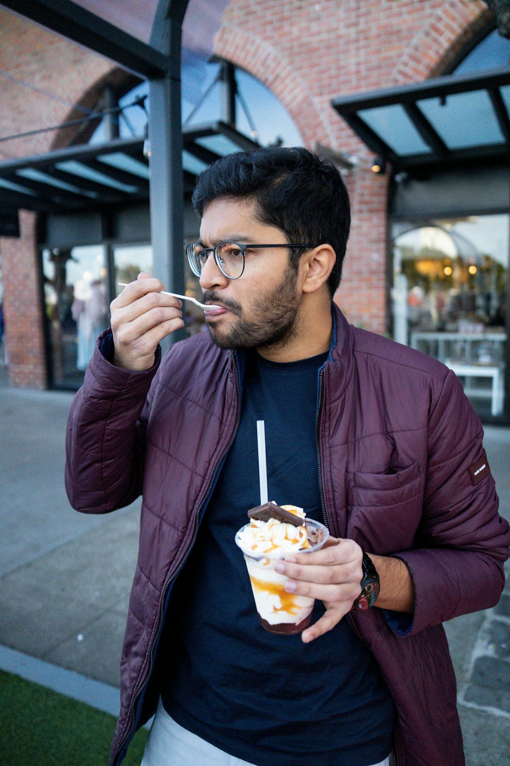 Un hombre con una chaqueta púrpura está comiendo comida