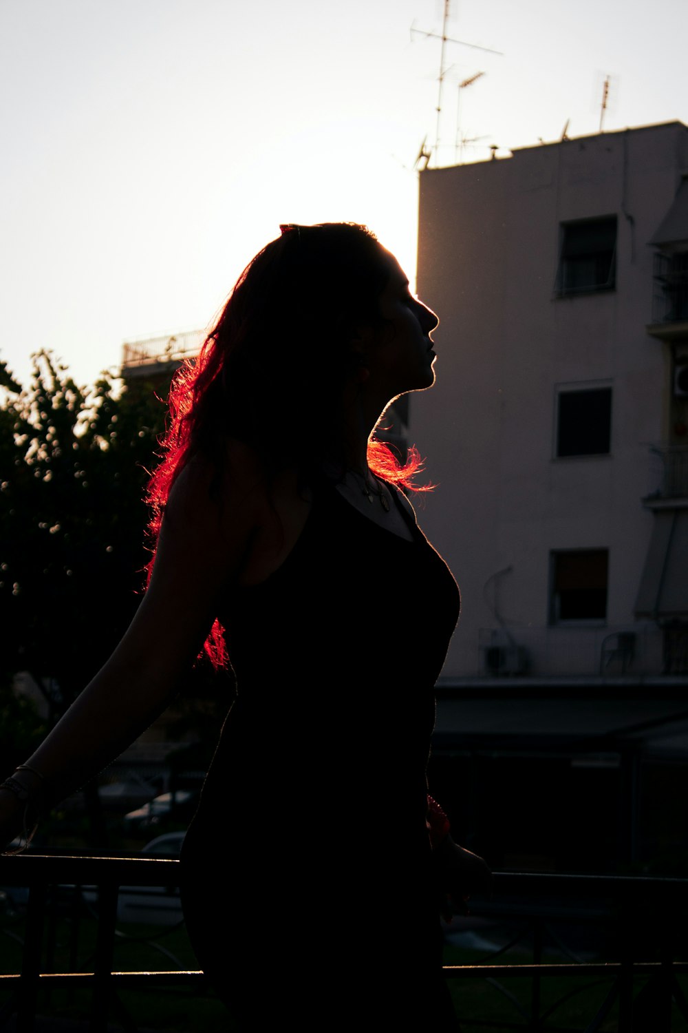 a woman with red hair standing in front of a building