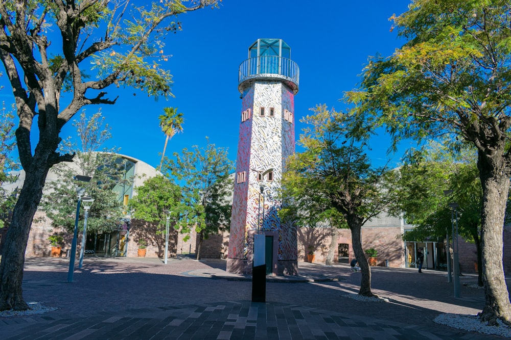 a tall tower sitting between two trees in a park