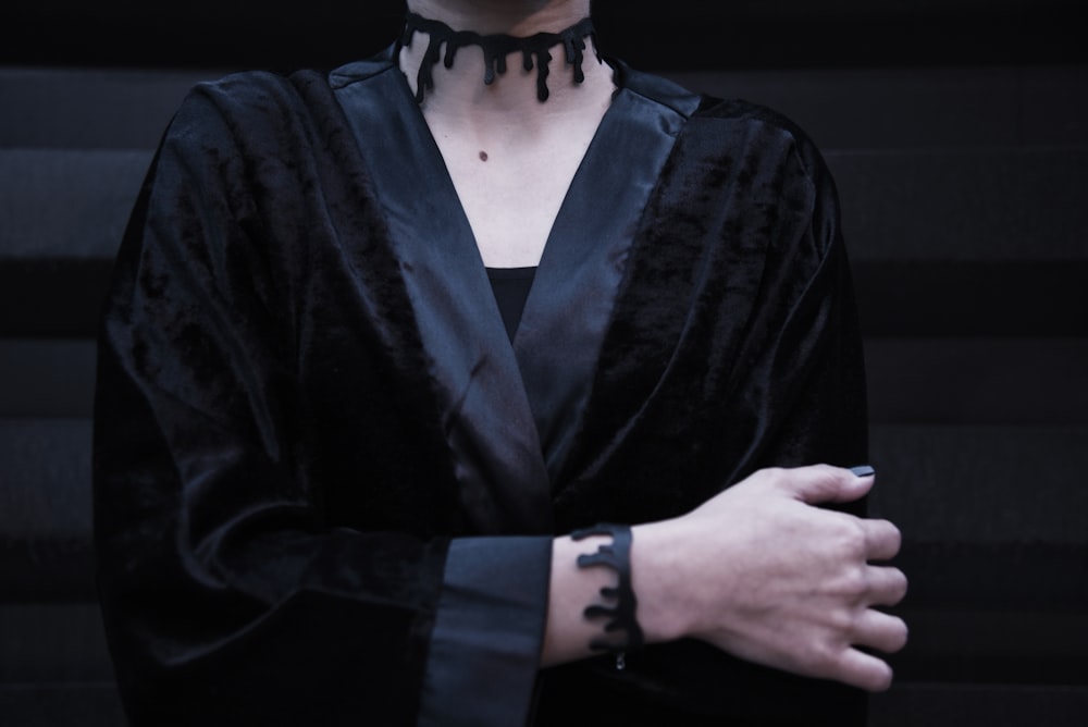 a woman in a black dress with a black choker on her neck