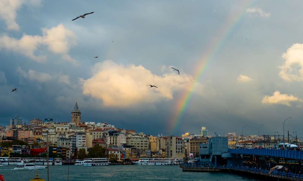 a rainbow in a cloudy sky over a city