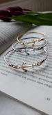 A bracelet with colorful gemstones draped over a vintage book, capturing a cozy vibe.