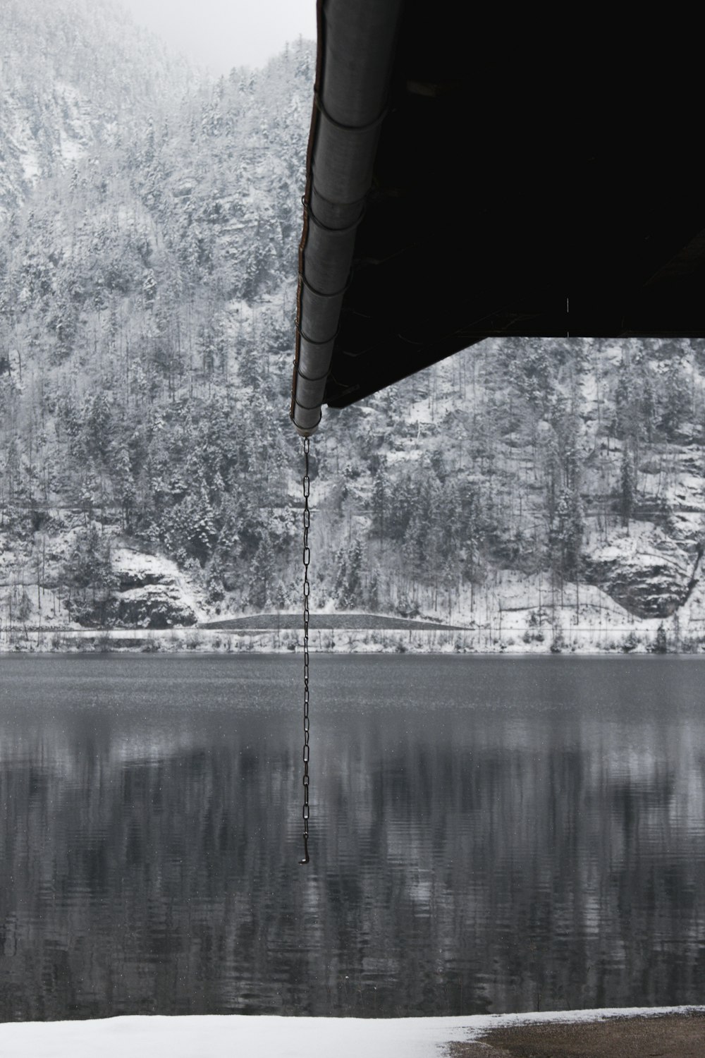 a black and white photo of a lake and mountains