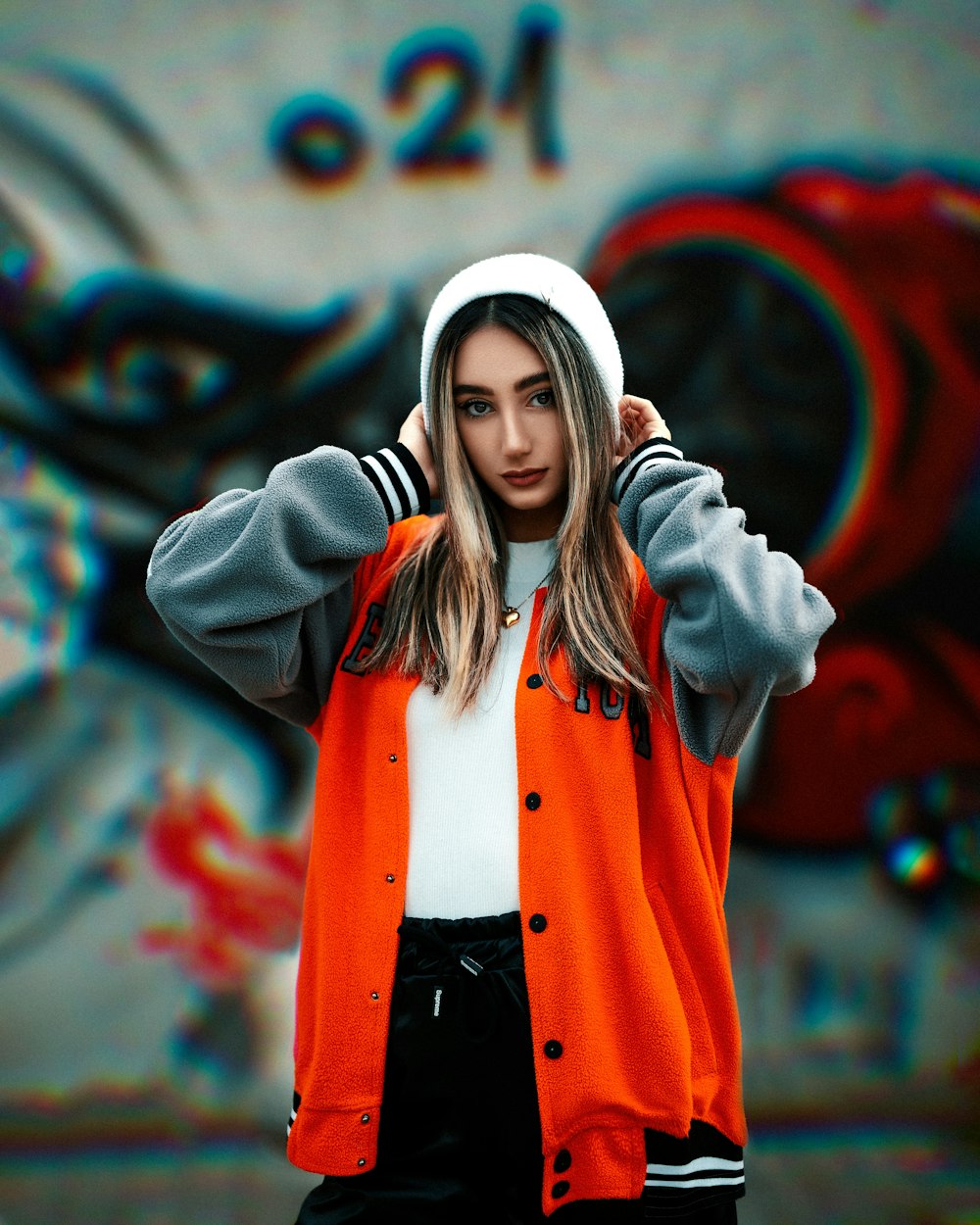 a woman in an orange jacket and white hat