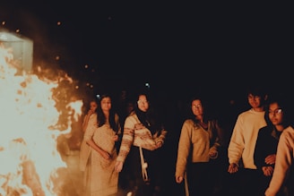 a group of people standing around a fire pit