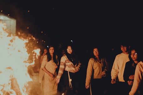 a group of people standing around a fire pit