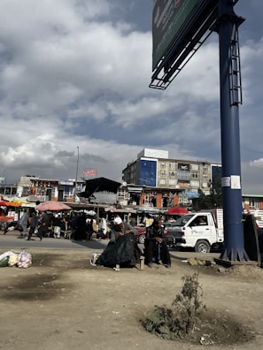 A crowded street market in Thailand under a cloudy sky.