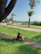 Man enjoying reading an ebook on a park bench during a sunny day.