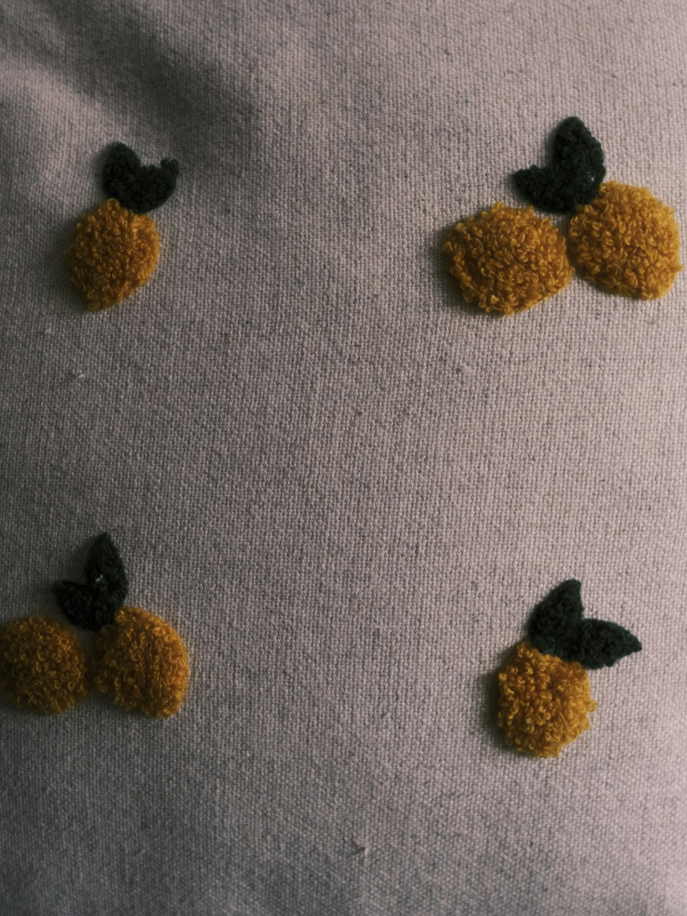 a close up of a sweater with crocheted fruit on it