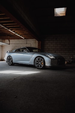 A sleek, polished car parked in a sunlit garage.