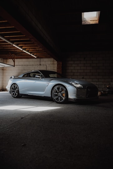 A sleek, polished car parked in a sunlit garage.