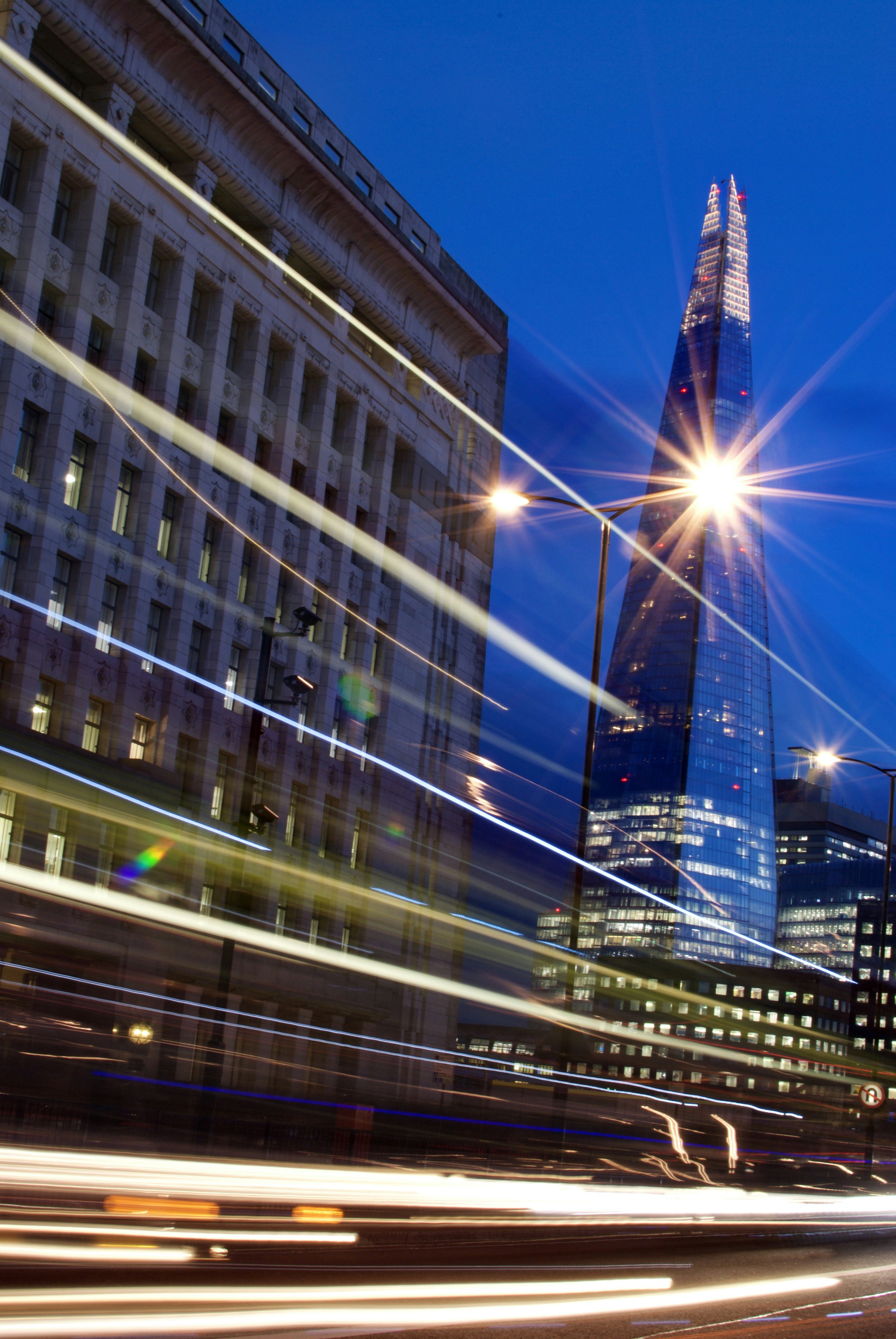 View of A very tall building towering over a city at night photo – Free London ...