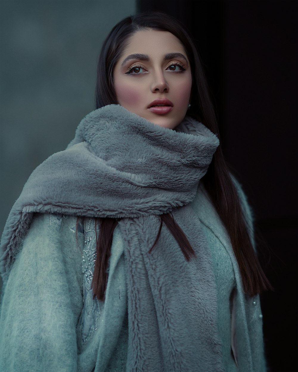 a woman wearing a fur coat and a scarf