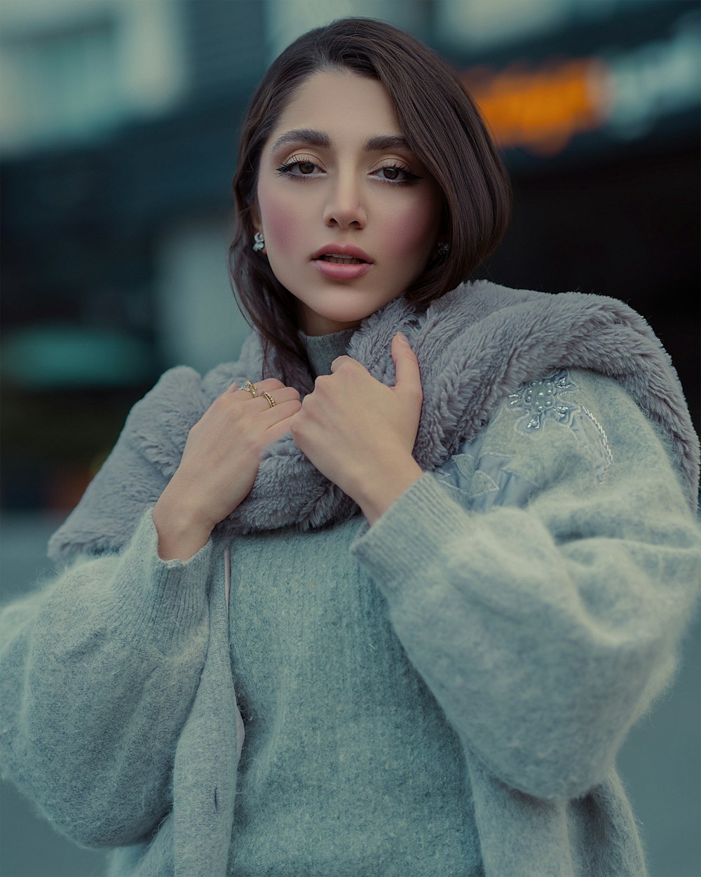 a woman in a gray coat is posing for a picture