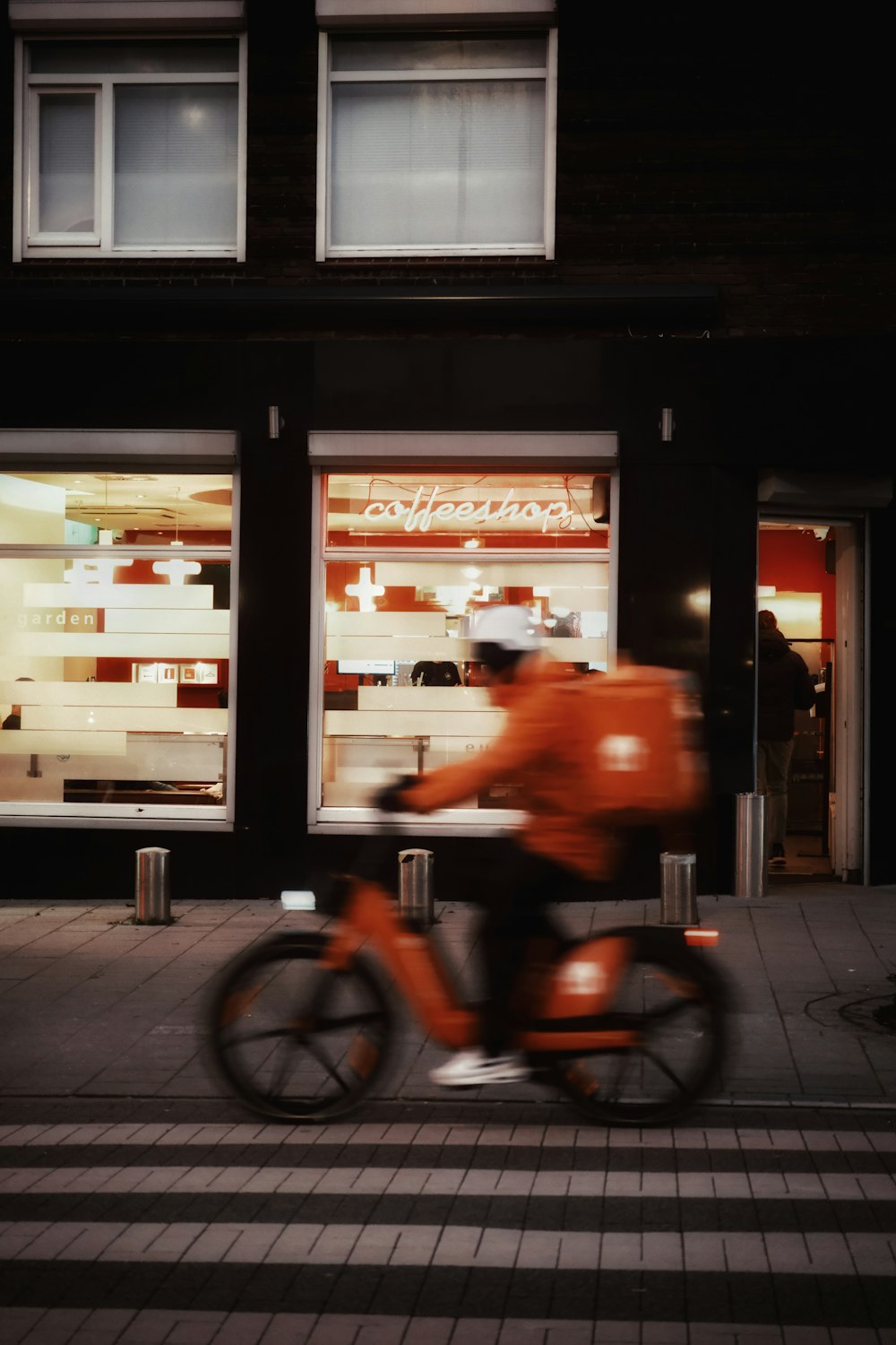 a man riding a bike past a store front