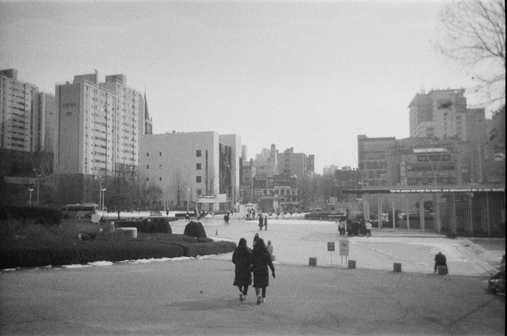 a black and white photo of people walking in a city