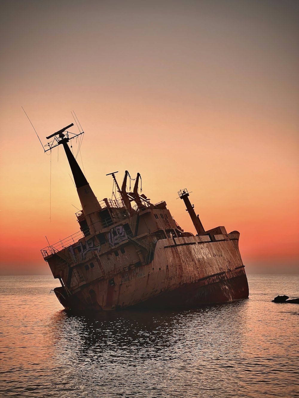 an old rusted ship in the middle of the ocean