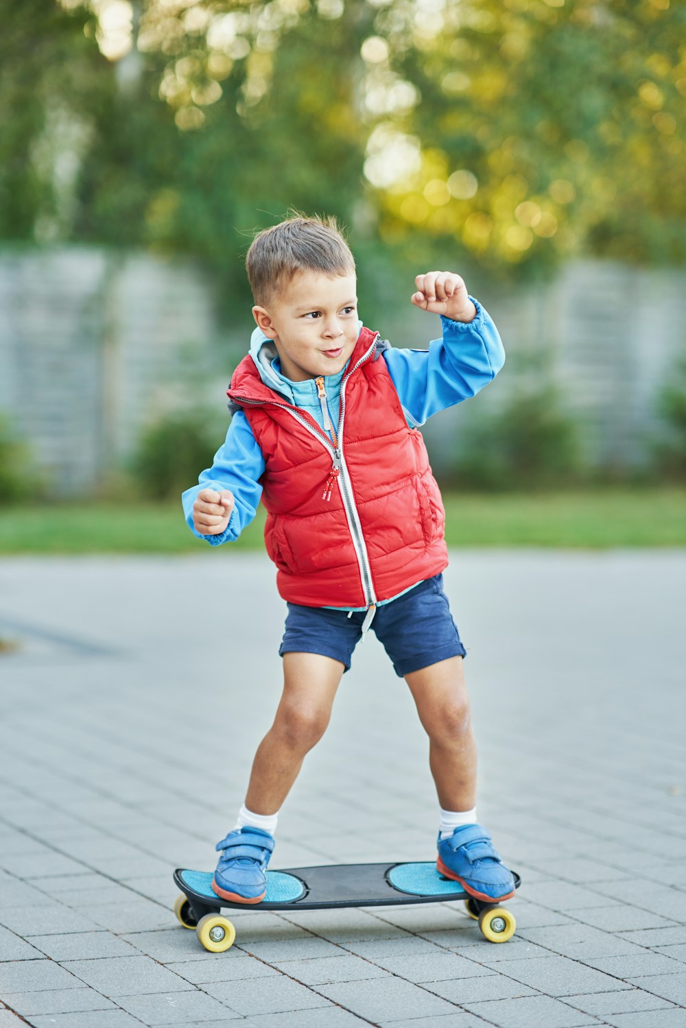 a young boy riding a skateboard on a sidewalk