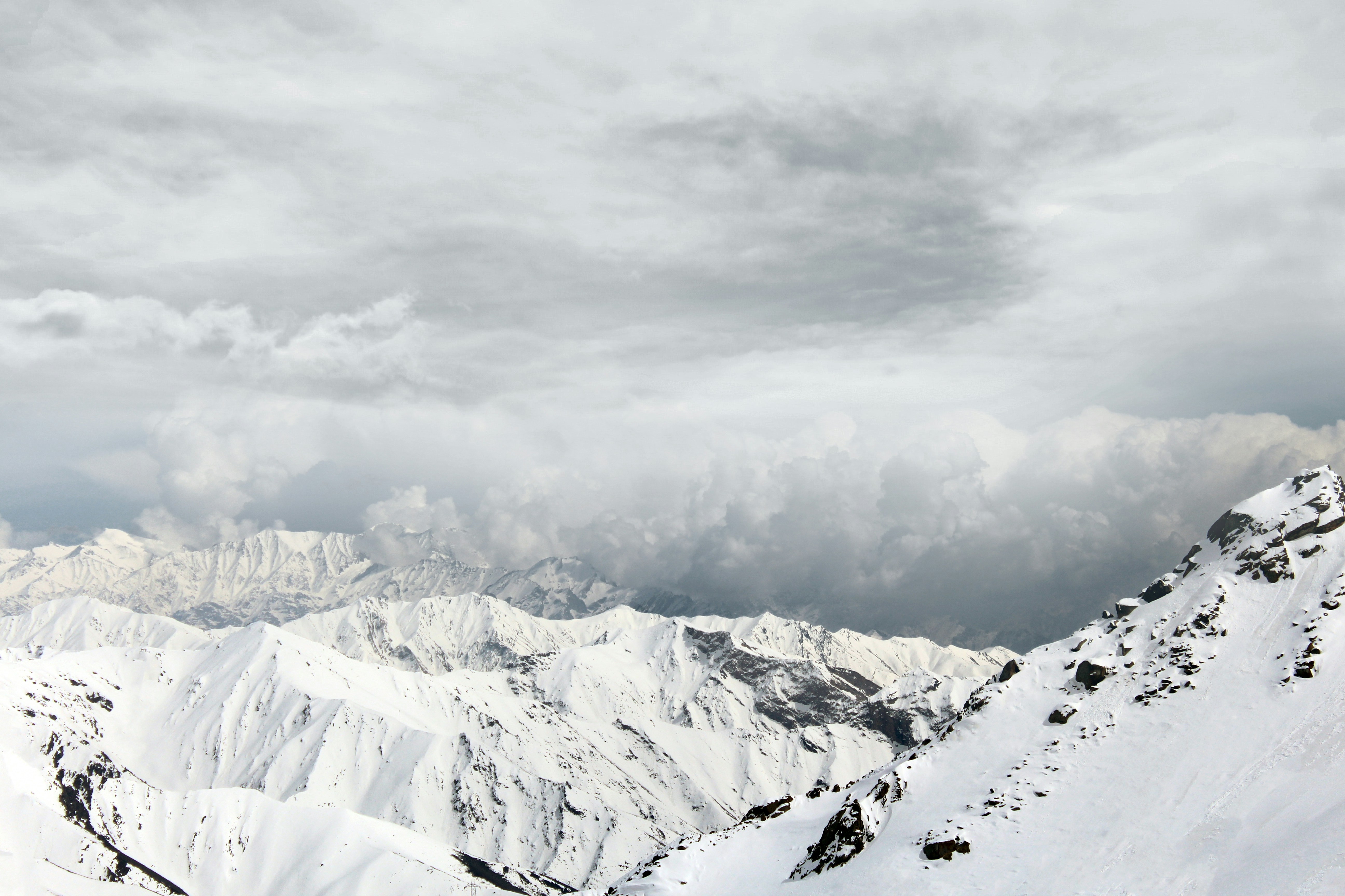 a snow covered mountain range under a cloudy sky, A view of the Salang Mountains range 2012. Salang mountains are a group of Hindu Kush mountains in Parwan province and Baghlan province in the northeast of Afghanistan.