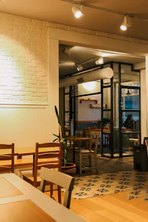 Cozy cafe interior featuring teak wood look PVC flooring with soft lighting and elegant furniture.