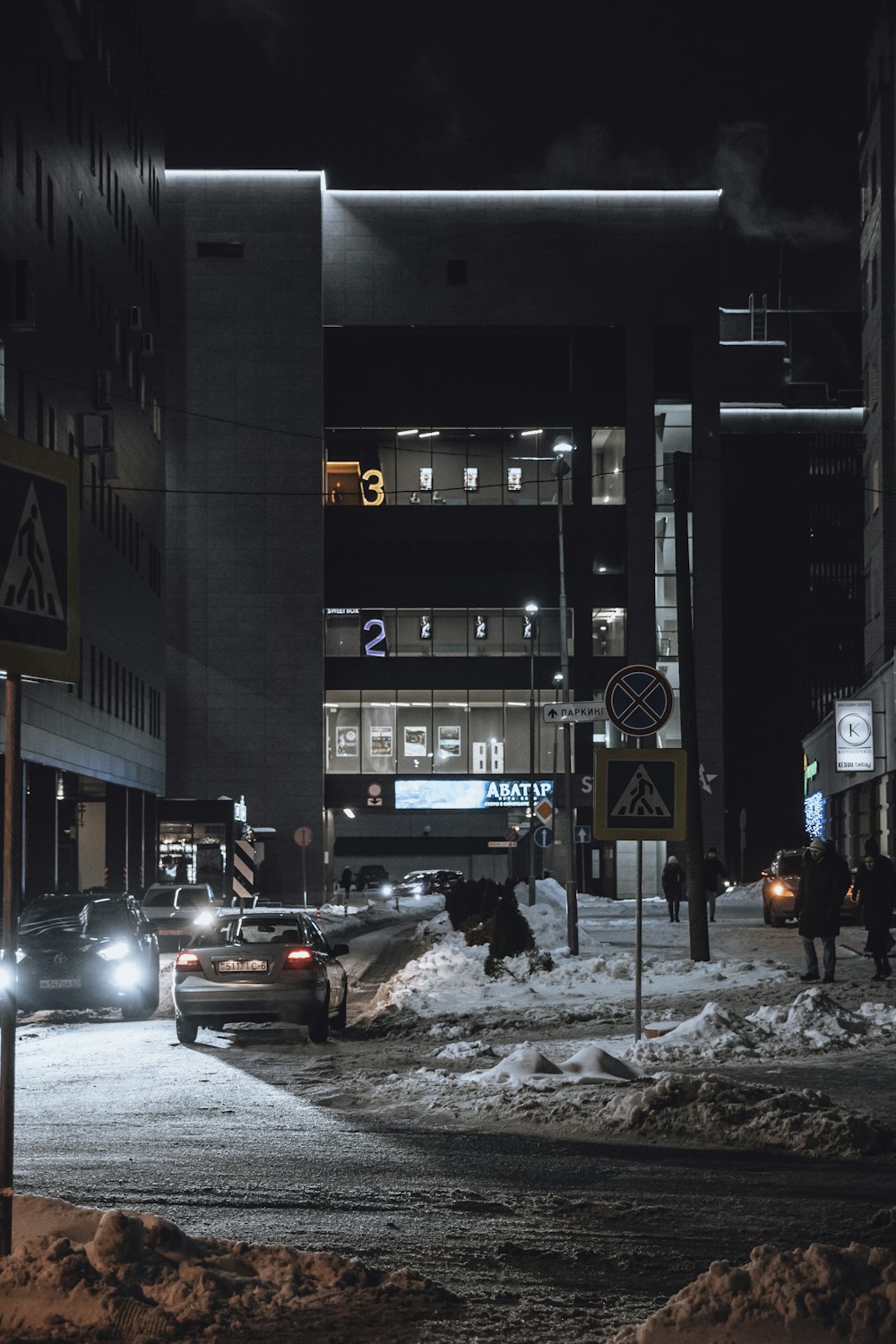 a couple of cars parked on a snowy street