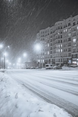 a city street is covered in snow at night