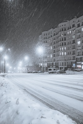 a city street is covered in snow at night