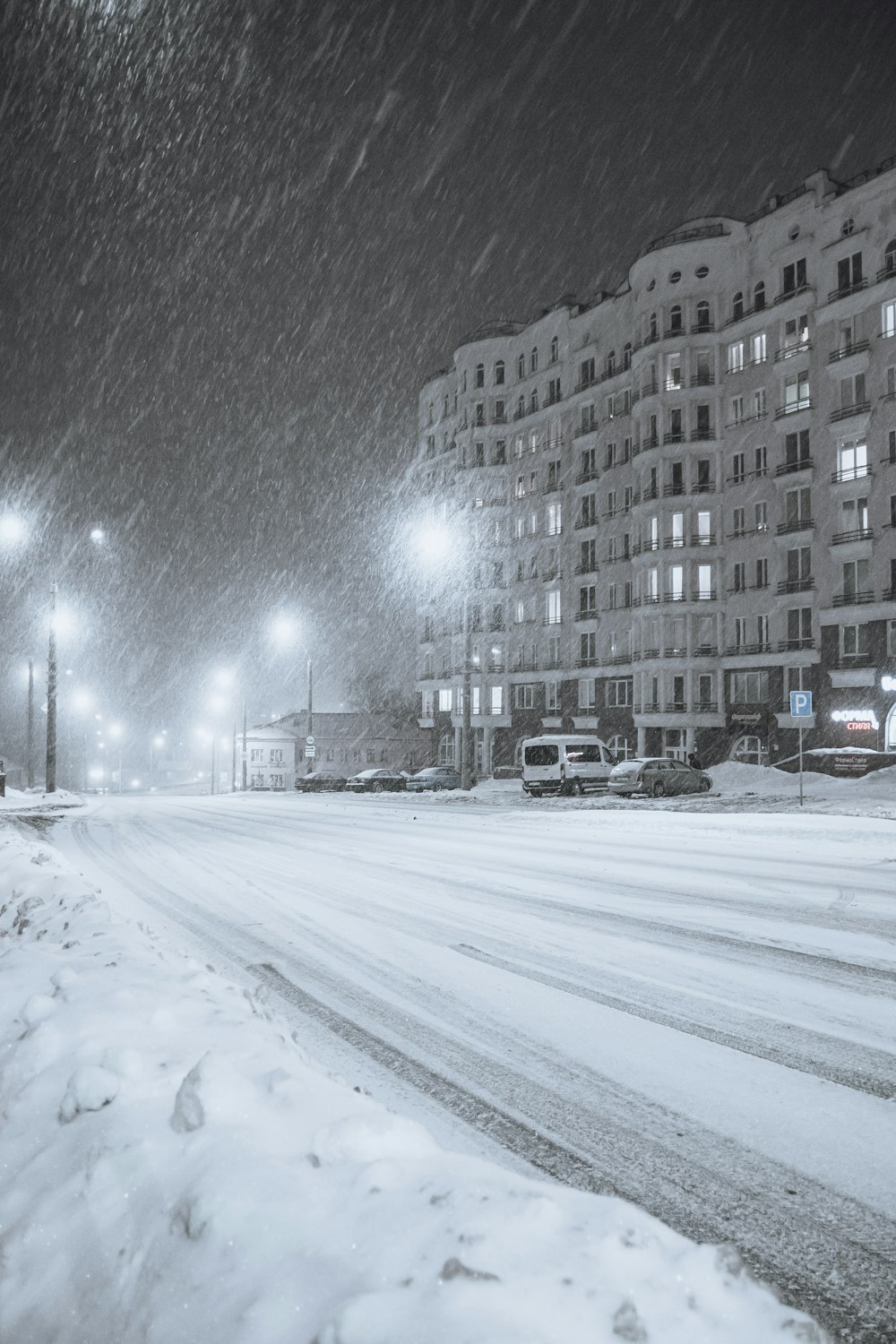 a city street is covered in snow at night